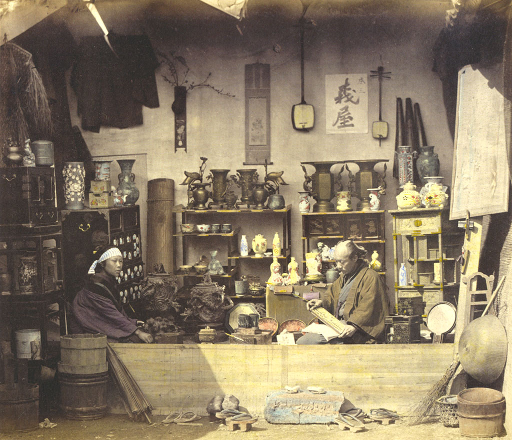 Two people sitting in an open-fronted shop
