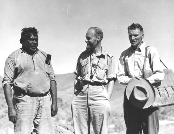 Three men standing outside, shown from the knees up.