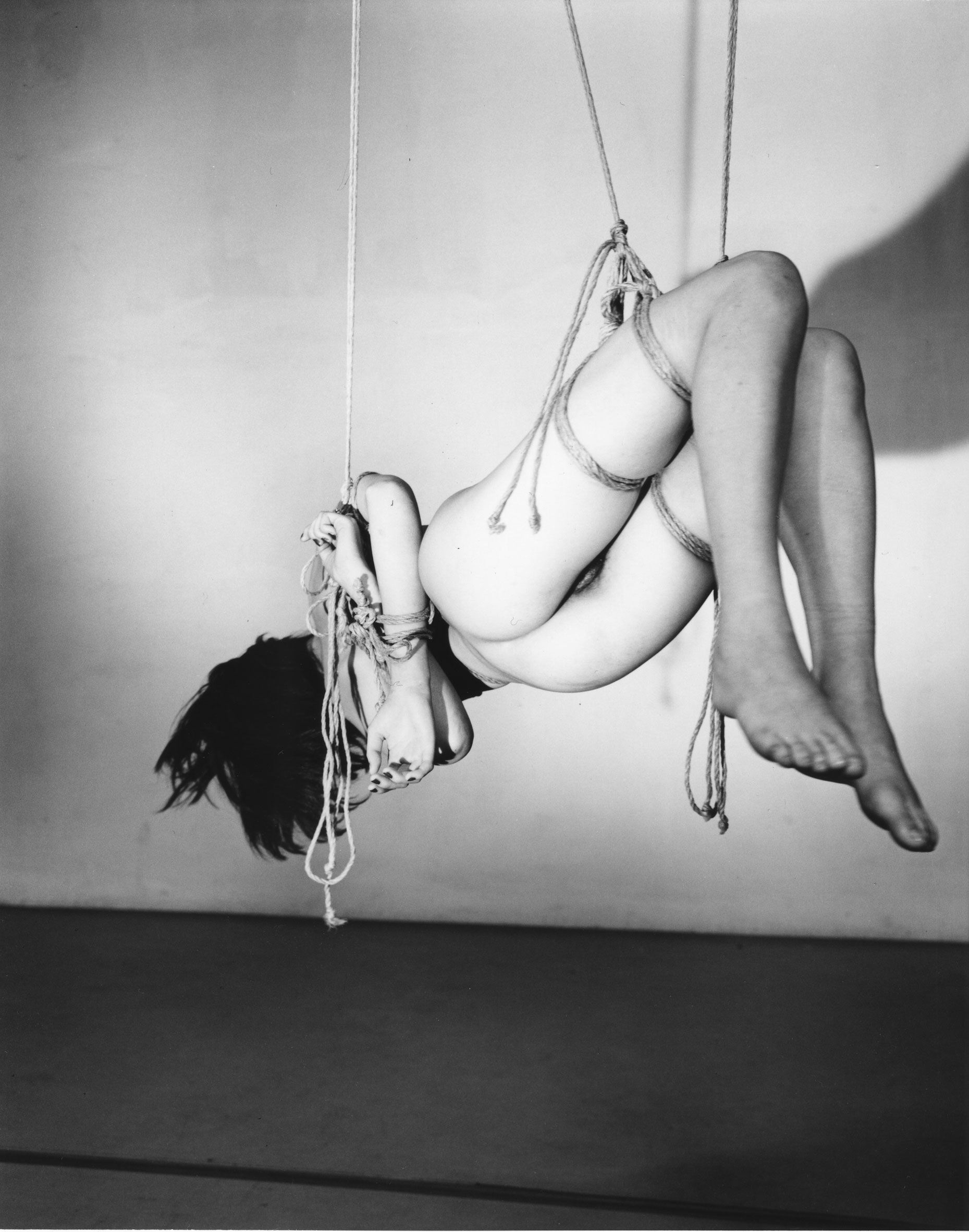 Photograph of a bound, naked woman hanging
