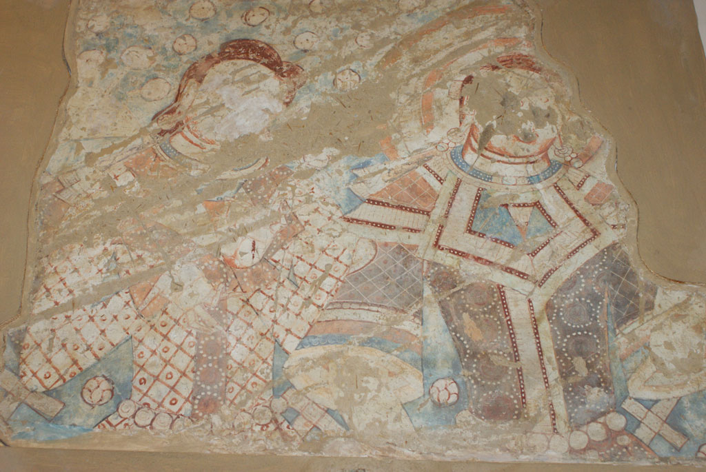 Two human figures, ornately dressed, shown from the waist up and looking to the right