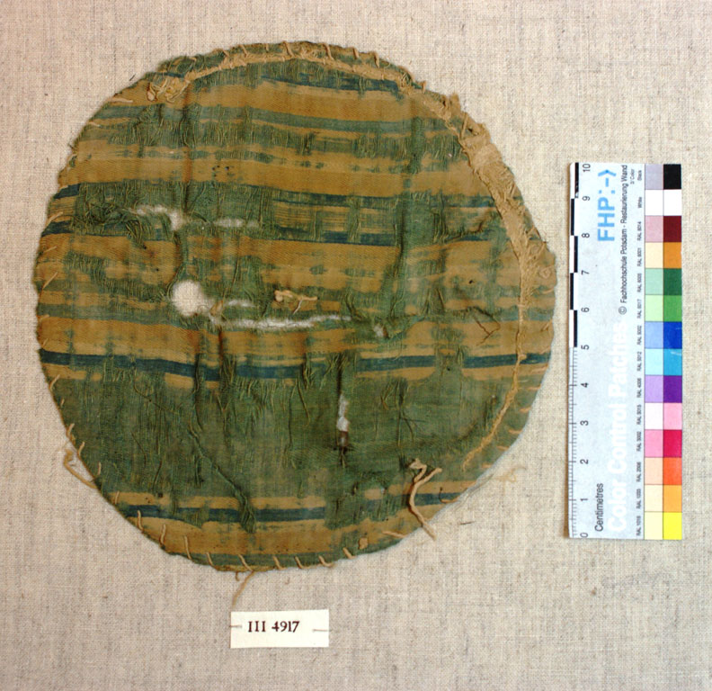 Tattered circle of fabric with horizontal green and yellow stripes