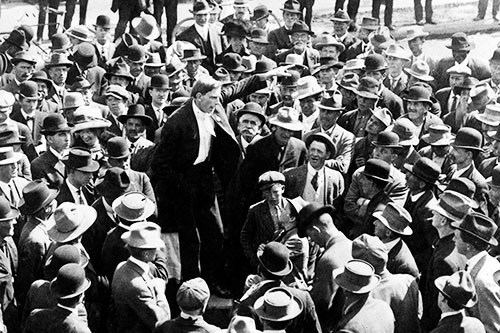 black and white photo of a crowd ofmen in suits and hats