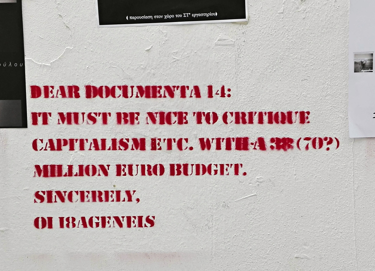 Block letter graffiti: Dear Documenta 14: It must be nice to critique capitalism etc. wtih a 38 (70?) million euro budget. Sincerely, OI I8ageneis